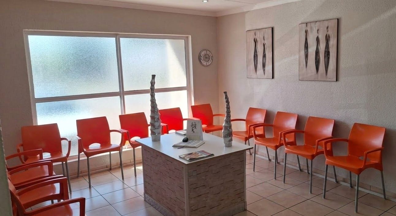 Bright waiting room with orange chairs at Hippocrates Health World, Glen Marais, Kempton Park